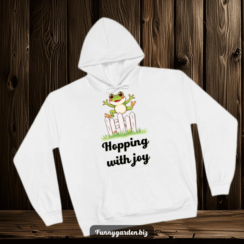 Funny kawaii frog hoodie joyfully leaping over a miniature, stylized garden fence, a cozy whimsical garment.